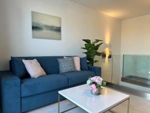 a blue couch in a living room with a table at Duplex Penthouse Prime Location in St Julian's