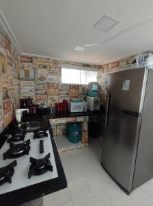 una cucina con frigorifero in acciaio inox e lavello di Apto pé na Areia a Ilha do Frade Altre 7 foto