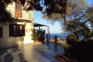 a house with a balcony and a view of the ocean at Fiorerosa in Santa Maria Navarrese
