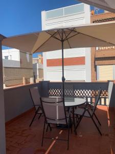 a table and chairs under an umbrella on a balcony at Apartamento El Atardecer in El Perelló +5 photos
