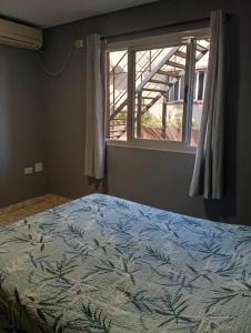 ein Schlafzimmer mit einem Bett und einem Fenster in der Unterkunft Las Palmas Village in Puerto Iguazú