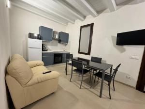 a living room with a couch and a table with chairs at Le casuzze in Locogrande
