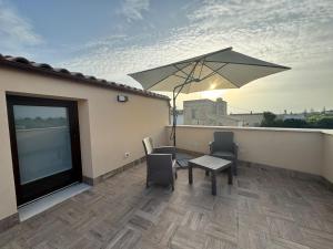 a patio with a table and an umbrella on a roof at Le casuzze in Locogrande