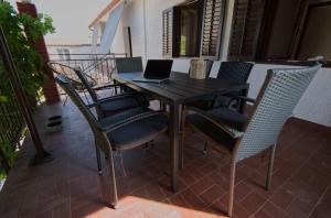 a wooden table with chairs and a laptop on it at Apartment Poli šterne, two rooms and pet friendly in Rakalj