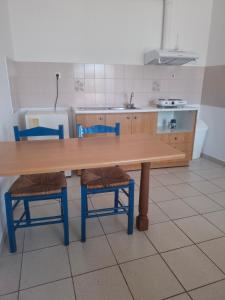 a kitchen with a wooden table and two chairs at Agnanti Kotsikia in Kotsikiá +26 photos