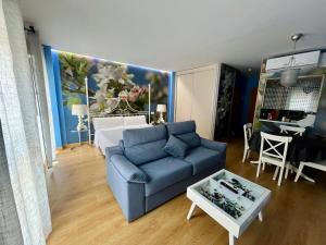 a living room with a blue couch and a table at Apartamentos Suites Capitolio in Mérida