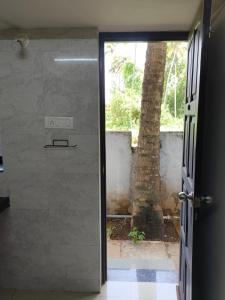 a door leading into a room with a palm tree at Coconut Inn - Parra Goa in Mapusa