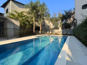 a swimming pool in a yard with a house at AP BOHO 1010 Brás - Piscina Aquecida, WiFi, Academia, Cama Casal box e colchão extra solteiro in Sao Paulo