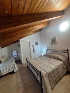 a bedroom with a large bed and wooden ceilings at Casa Helvius - Dimora in centro storico in Sant'Egidio del Monte Albino