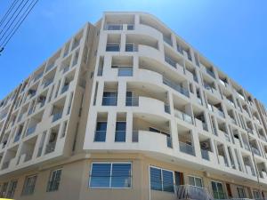 a tall white apartment building with windows at Flavia and Angelo's house in St. Paul's Bay