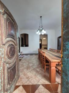a dining room with a wooden table and chairs at Hospedaria Casarão in Cananéia