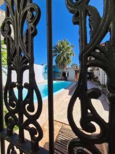 a view of a pool through a iron gate at Hospedaria Casarão in Cananéia