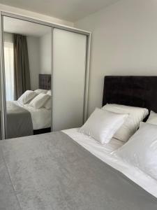 a bedroom with two beds and a large mirror at Apartmani Villa Antea in Klek +111 photos