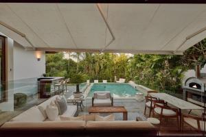 una piscina con muebles blancos y una piscina en Casa Mia Villa, en La Romana
