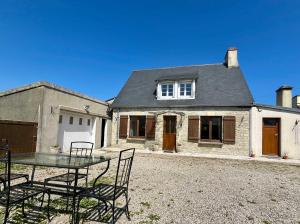 a table and chairs in front of a house at La Maison d Utah Beach and Memory in Sainte-Marie-du-Mont +30 photos