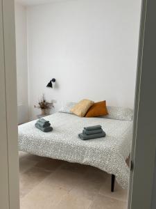 a bed in a white room with towels on it at Casalento in Ceglie Messapica