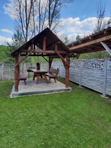 a picnic shelter with a picnic table and a bench at Agroturystyka za wodą - apartamenty in Kacwin