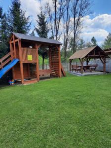 a gazebo and a playground with a slide at Agroturystyka za wodą - apartamenty in Kacwin