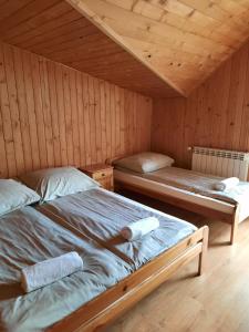 a bedroom with two beds in a wooden cabin at Agroturystyka za wodą - apartamenty in Kacwin +9 photos
