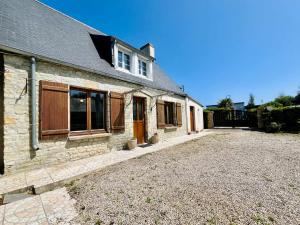 a stone house with a driveway in front of it at La Maison d Utah Beach and Memory in Sainte-Marie-du-Mont