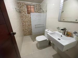 a bathroom with a white toilet and a sink at Family Apartment in San Isidro in Mendoza +7 photos