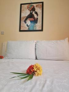 a flower on a white bed with a picture on the wall at Amazon Villas in Soufrière +12 photos