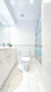 a white bathroom with a toilet and a sink at CSS Cheerful Smart Superior 2BD Townhouse Limnaria Gardens in Paphos City