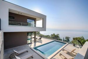 a modern house with a swimming pool and the ocean at Villa Marmonte, Luksuzna vila s bazenom i pogledom na more in Medveja