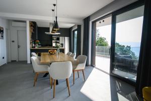 a kitchen and dining room with a table and chairs at Villa Marmonte, Luksuzna vila s bazenom i pogledom na more in Medveja