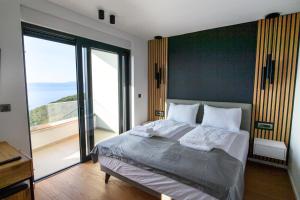 a bedroom with a large bed with a large window at Villa Marmonte, Luksuzna vila s bazenom i pogledom na more in Medveja +32 photos