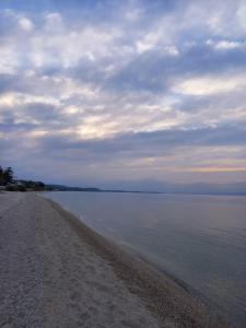 a beach with a cloudy sky and the water at Κόσμος apartment in Polykhrono