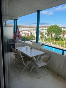 a table and chairs on a balcony with a view of a building at Appartement du Golf de Ciboure in Ciboure