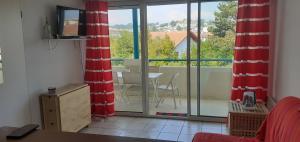 a living room with a view of a balcony at Appartement du Golf de Ciboure in Ciboure