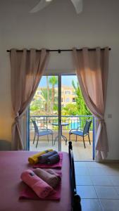 a bedroom with a bed with a view of a balcony at CSS Cheerful Smart Superior 2BD Townhouse Limnaria Gardens in Paphos City