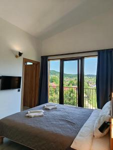 a bedroom with a bed and a large window at Nafta APARTS in Skhidnitsa
