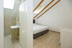 una camera bianca con letto e lavandino di Apartments and Rooms Zvjezdana a Hvar