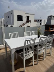 a white table and four chairs on a balcony at Casa Sara seaview in Playa Honda