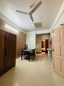a dining room with a table and a ceiling fan at Miss Tea Home in Agartala