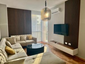 a living room with a couch and a tv at Sea Apartment in Lezhë