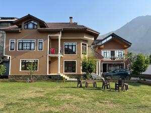 una casa con sedie e un tavolo di fronte ad essa di Haven Retreat a Srinagar