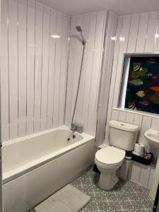 a bathroom with a toilet and a tub and a sink at Home away Tamworth Staffordshire 4 Bedroom 3 Bathroom - Semi Detached House in Glascote +60 photos