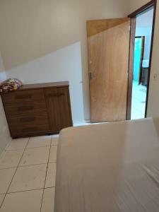 a bedroom with a bed and a wooden door at Casa perto da Uopecan in Cascavel +10 photos