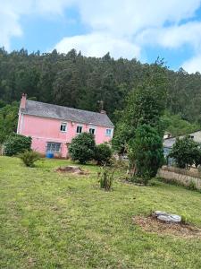 TrabadaにあるCasa de Campo en Xuga, Trabadaの畑中のピンクの家