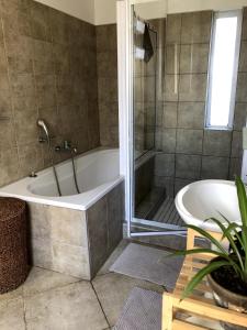 a bathroom with a bath tub and a sink at Waterfront Stay Holiday Home in Swakopmund