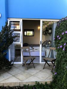 a room with a bed and two chairs on a patio at Waterfront Stay Holiday Home in Swakopmund