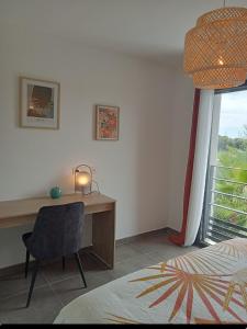 a bedroom with a desk and a bed and a window at maison jardin tram,mer 15mn voiture in Saint-Jean-de-Védas +13 photos