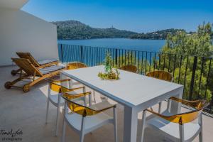 ein Tisch und Stühle auf einem Balkon mit Blick auf das Wasser in der Unterkunft Discover Lastovo premium accommodation in Skrivena Luka