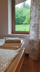 a bedroom with a bed with a window and a curtain at Apartamenty Marii Kawik in Brenna