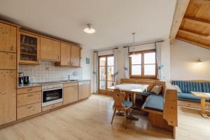 a kitchen with a table and a dining room at Hofer am Bach in Lagundo