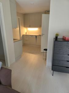 a room with a kitchen with white cabinets and a table at Two bedrooms Luxury apartment with free parking in Lorenskog